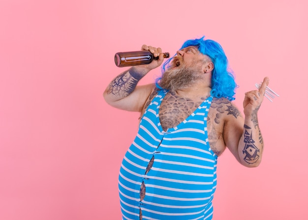 Homem gordo com barba e peruca fuma cigarros e bebe cerveja