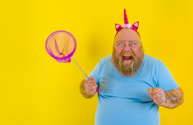 Homem gordo e feliz com bandana brincando com rede marítima