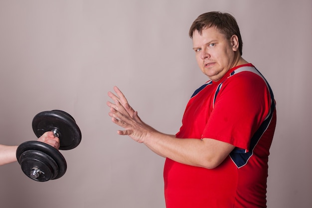 Foto homem gordo se recusa a praticar esportes.