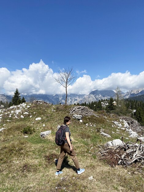 homem goza de vistas sobre a aldeia alpina nas montanhas. Velika Planina. Planalto do Grande Pasto. Eslovênia