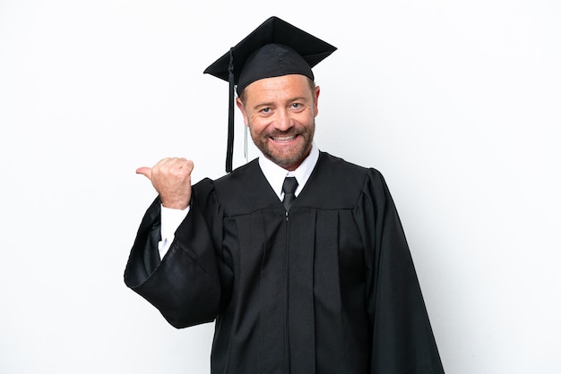 Homem graduado universitário de meia idade isolado no fundo branco, apontando para o lado para apresentar um produto