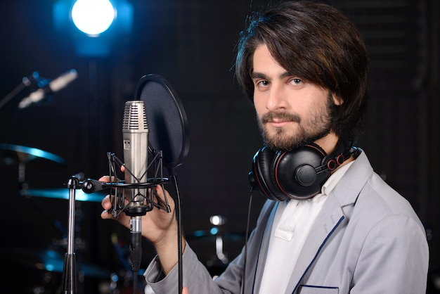 Homem gravando uma música em um estúdio profissional.