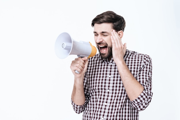 Homem grita em um megafone de dor