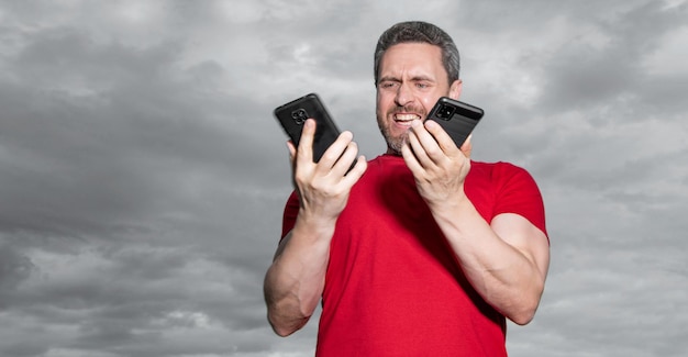 homem gritando e falando ao telefone no fundo do céu homem falando ao telefone ao ar livre homem falando ao telefone usa camiseta vermelha foto do homem falando ao telefone