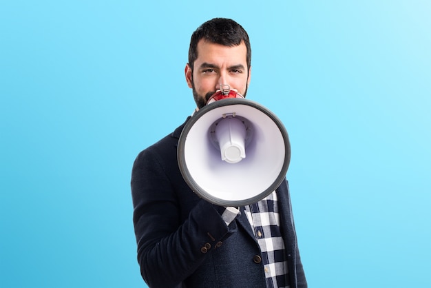 Homem gritando por megafone em fundo colorido