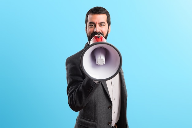 Homem gritando por megafone em fundo colorido