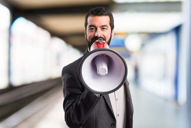 Homem gritando por megafone em fundo não focado