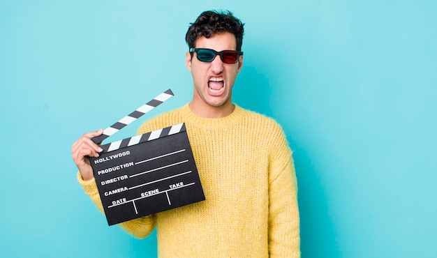 Homem hispânico bonito gritando agressivamente olhando o conceito de cinema muito irritado