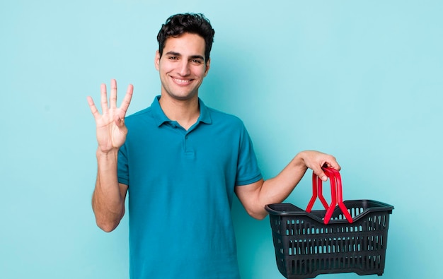 Homem hispânico bonito sorrindo e parecendo amigável mostrando o conceito de cesta de compras número quatro