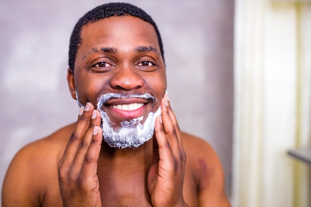 Homem hispânico coloca espuma na loção de perfume de barba ou creme de cuidados com a pele para pele sensível