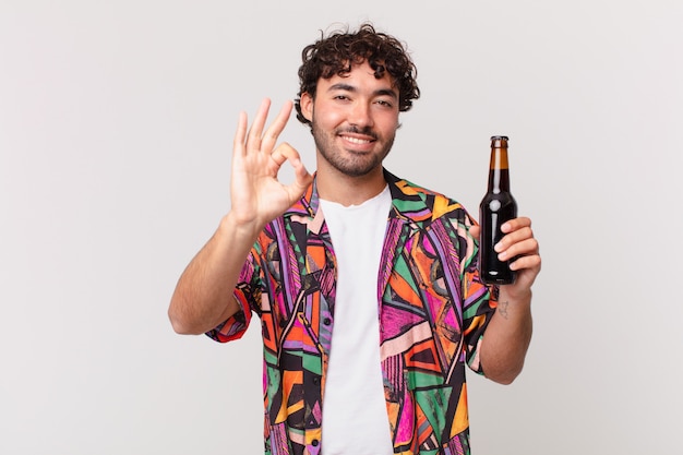 Homem hispânico com cerveja se sentindo feliz, relaxado e satisfeito, mostrando aprovação com gesto de ok, sorrindo