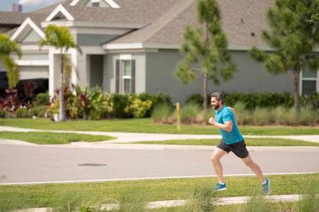Homem hispânico de meia-idade a correr lá fora de manhã, desportista sénior a desfrutar de atividade.