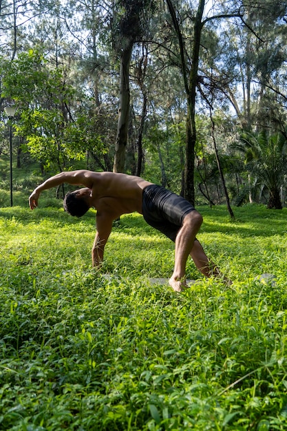 Homem hispânico e latino meditando no meio de uma floresta recebendo raios solares pele marrom méxico