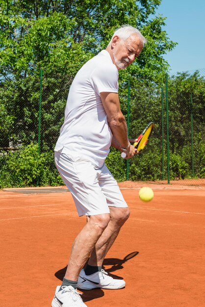 Homem idoso a jogar ténis.