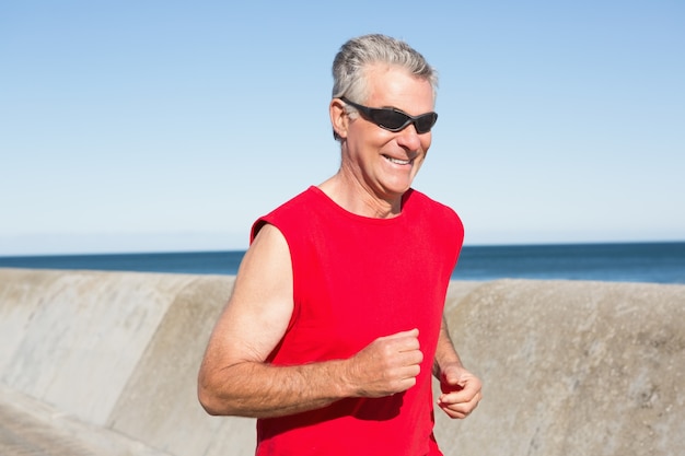 Homem idoso ativo jogging no pier