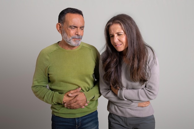 Homem idoso caucasiano infeliz e senhora sofrem de dor de estômago e sino