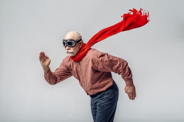 Homem idoso com lenço vermelho e óculos de piloto