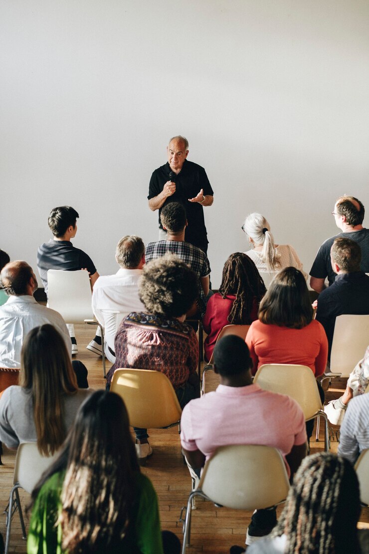 Foto homem idoso falando ao microfone em um seminário