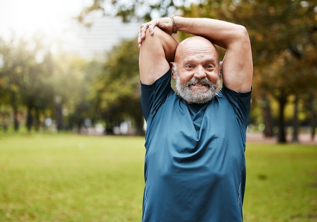 Homem idoso fitness e alongamento de braços para exercícios de treino ou treinamento na natureza ao ar livre Homem sênior em bem-estar para alongamento de braço de aquecimento no parque para exercícios saudáveis ou esportes ao ar livre