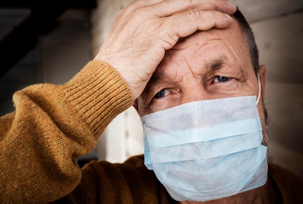 Homem idoso frio com uma máscara médica