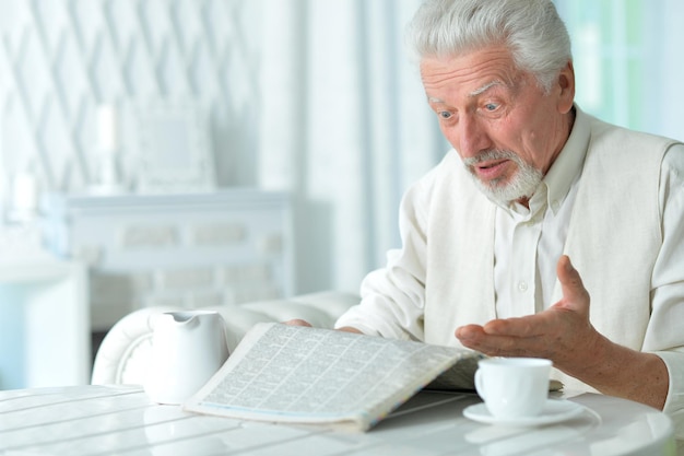 Homem idoso lendo um jornal