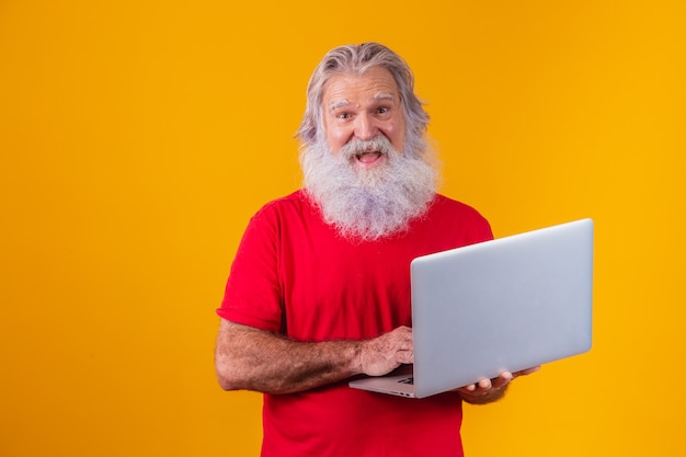 Homem idoso que trabalha com o laptop.