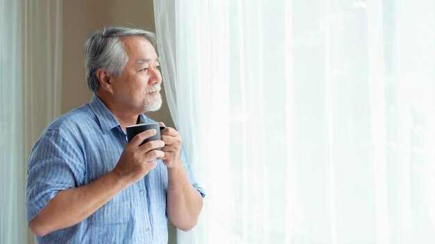 Homem idoso se sente feliz bebendo café pela manhã desfrutando do tempo em sua casa estilo de vida de fundo interno conceito de felicidade sênior