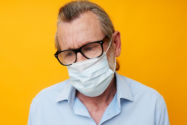 Foto homem idoso usando máscara contra fundo amarelo