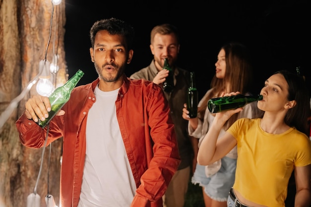 Foto homem indiano a beber cerveja sem parar a beber muita cerveja numa festa com amigos viciados em álcool