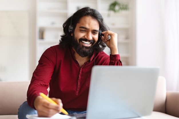 Foto homem indiano a estudar em casa a ver a lição online