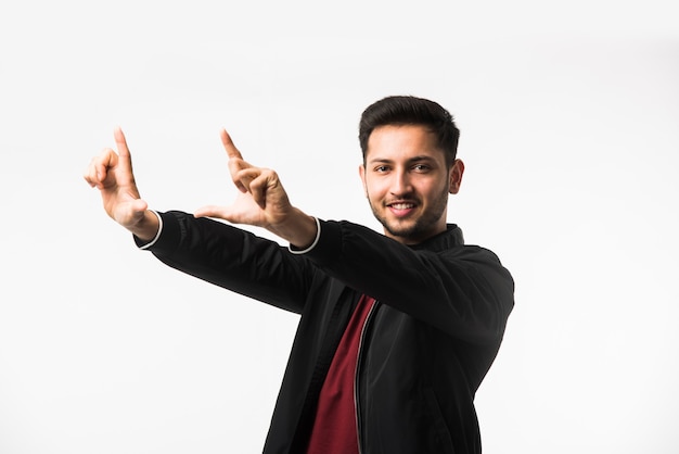 Homem indiano asiático fazendo uma moldura usando as mãos e os dedos, tentando encontrar uma visão perfeita, isolada no fundo branco