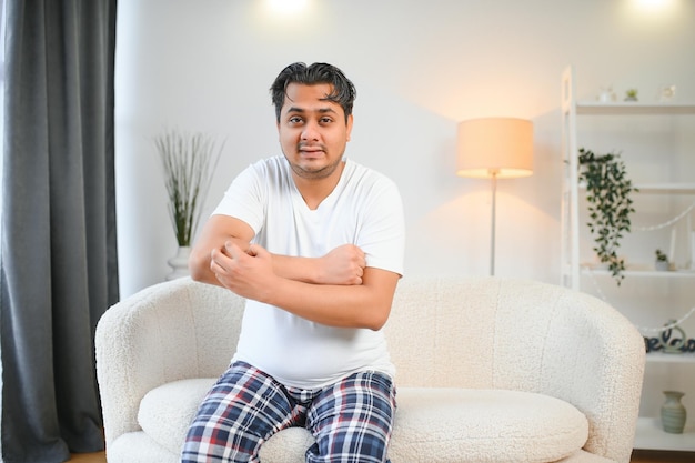 Foto homem indiano coçando a mão com comichão devido a uma doença alérgica à pele