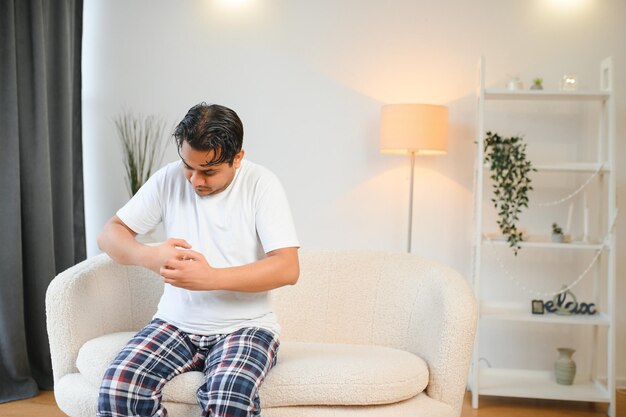 Foto homem indiano coçando a mão com comichão devido a uma doença alérgica à pele