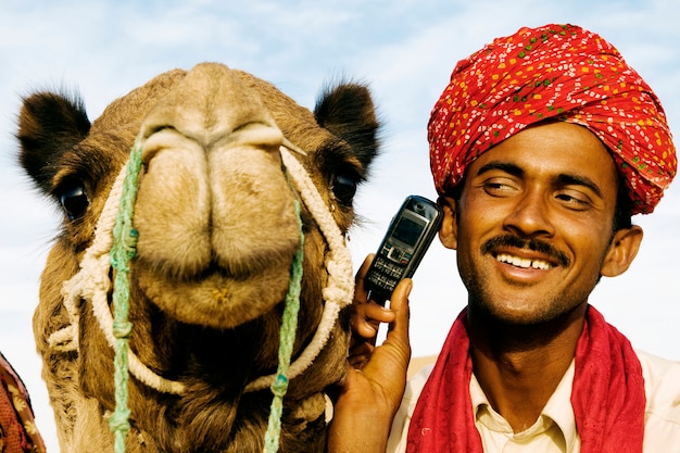 Homem indiano e camelo no telefone, rajasthan, índia.