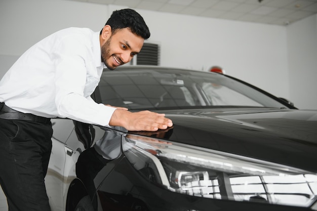 Homem indiano feliz compra novo automóvel ecológico de biodiesel no showroom de luxo