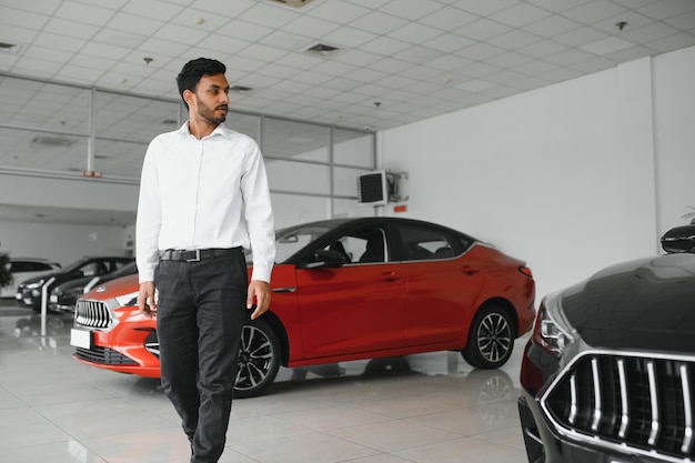 Homem indiano feliz compra novo automóvel ecológico de biodiesel no showroom de luxo