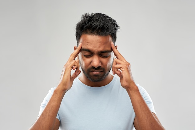 homem indiano infeliz sofrendo de dor de cabeça