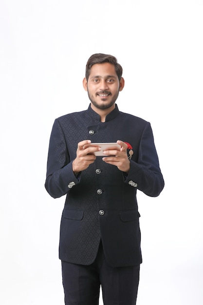 Homem indiano usando smartphone em fundo branco.