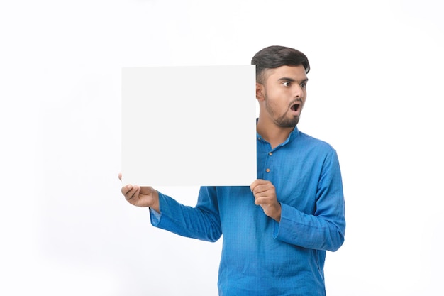 Homem indiano vestindo panos tradicionais e mostrando a placa no fundo branco.