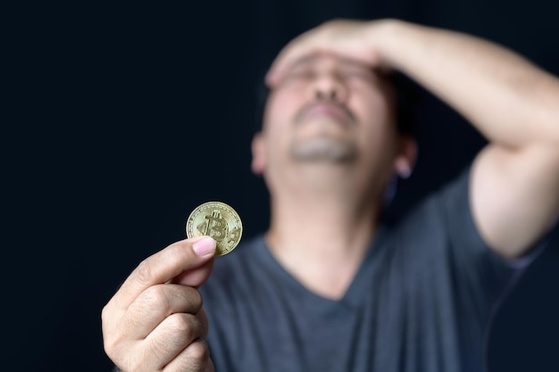 Homem intermediário segurando bitcoins e se sente estressado por causa da perda do conceito de negociação de criptomoedas online bitcoin
