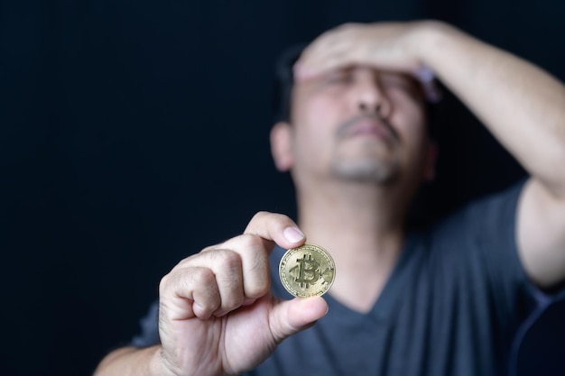 Homem intermediário segurando bitcoins e se sente estressado por causa da perda do conceito de negociação de criptomoedas online bitcoin