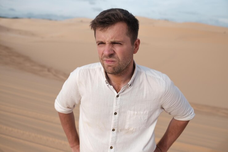 Homem irritado com careta no rosto sozinho no deserto Ele está perdido e cansado de fazer algo