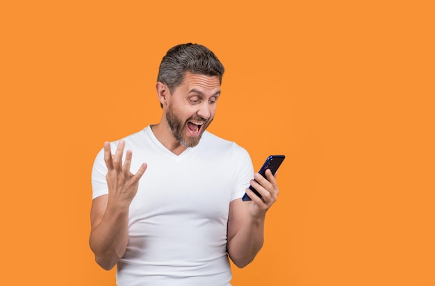 Homem irritado fala em smartphone isolado em homem amarelo fala em smartphone no estúdio