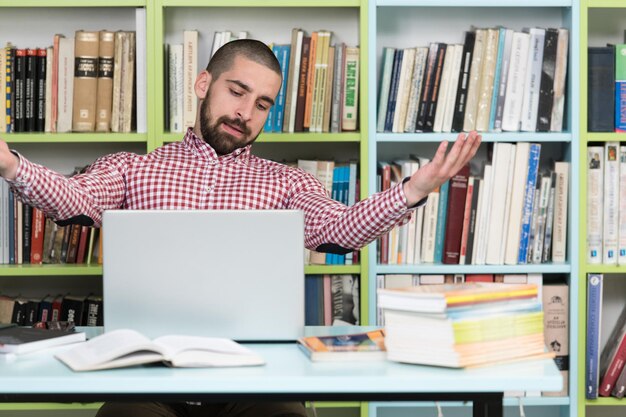 Homem irritado sentado na biblioteca