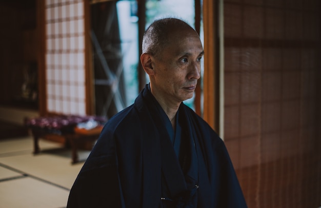 Homem japonês meditando em seu jardim