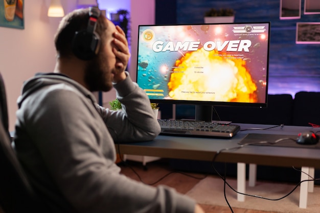 Homem jogador profissional jogando videogame de atirador espacial no computador para o campeonato. cyber desempenho em um pc poderoso na casa da sala de jogos durante o torneio online