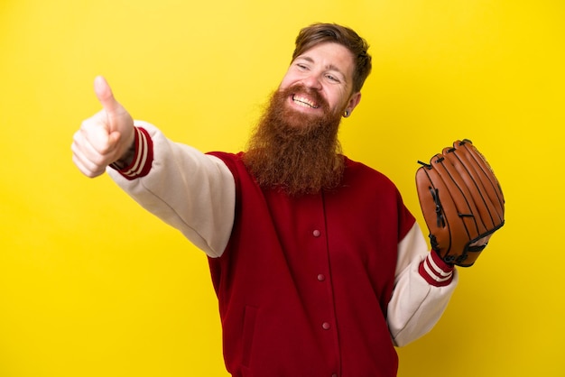 Homem jogador ruivo com barba com luva de beisebol isolado em fundo amarelo, dando um polegar para cima gesto