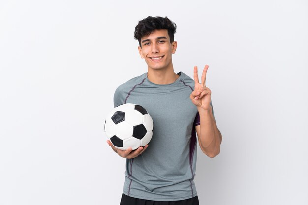 Homem jogando futebol muro isolado