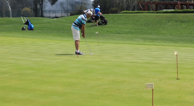 homem jogando golfe em um campo verde