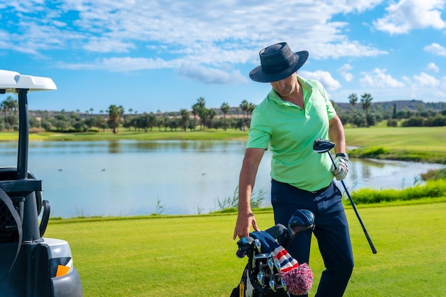 Homem jogando golfe pegando o taco após o lance na bolsa do taco